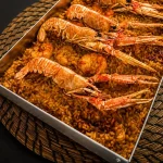Llanda de arroz con cigalas sobre la mesa